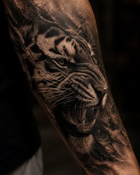 Tatouage réaliste de tigre en noir et gris sur avant-bras